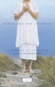 Naslovnica engleskog prijevoda teksta Ljudmile Ulicke pod naslovom "Medea and Her Children". Bosonoga osoba u bijeloj haljini stoji na pijesku, more je u pozadini.