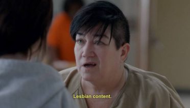 Krupni plan Big Boo, jedne od junakinja serije "Orange Is the New Black". Ispod fotografije piše: "Lesbian content."